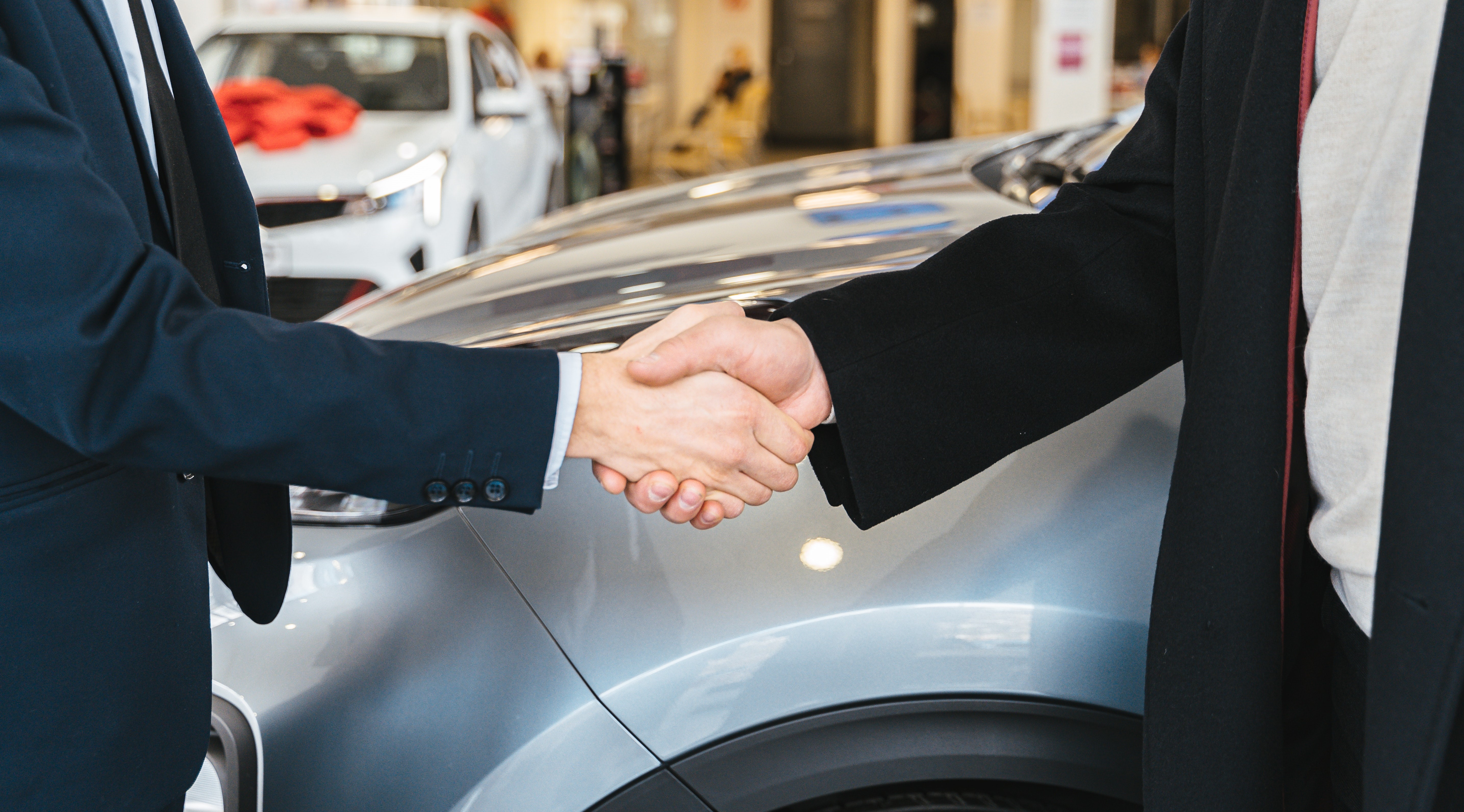 Two people in business suits shaking hands.