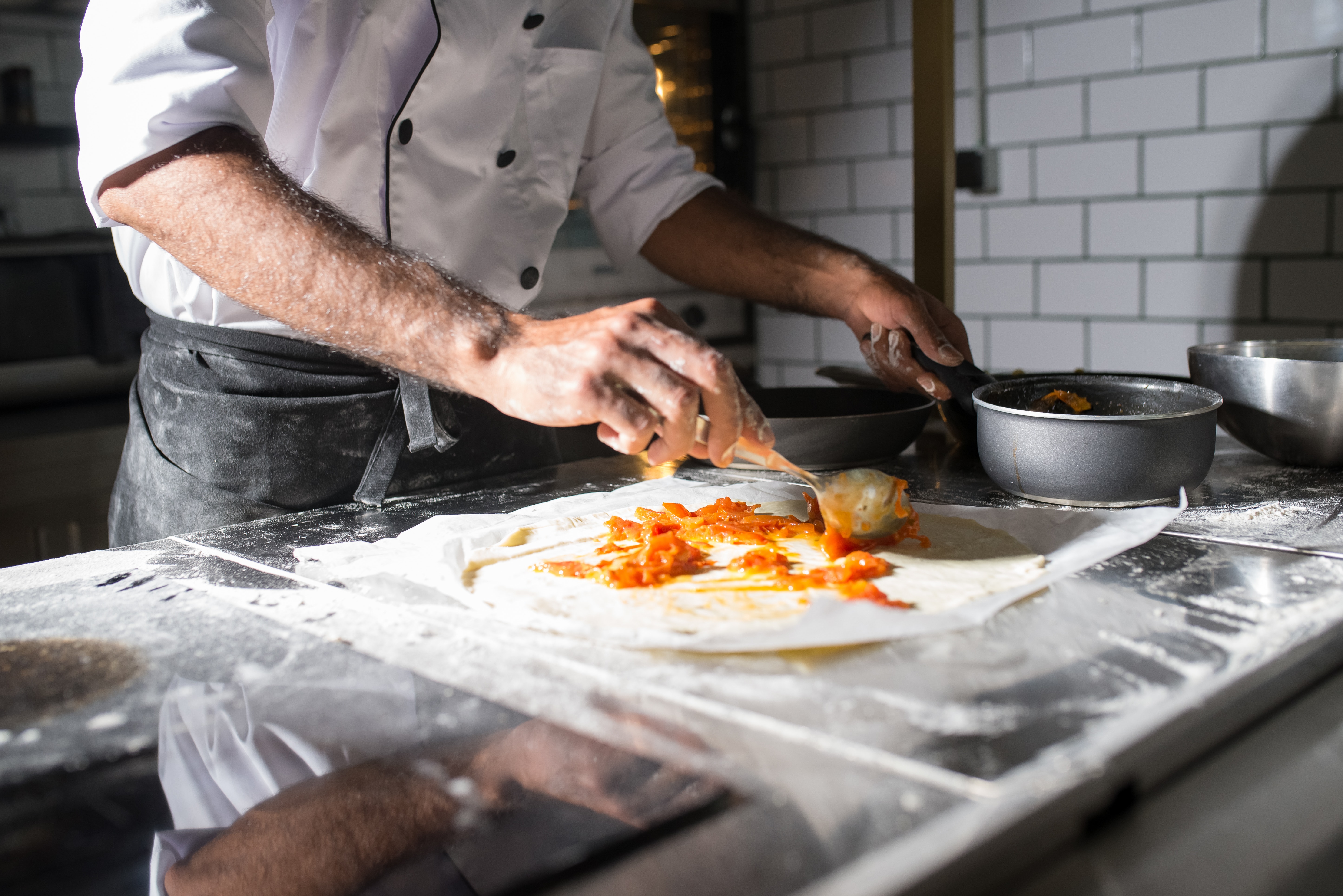 A person spooning filling onto a tortilla.