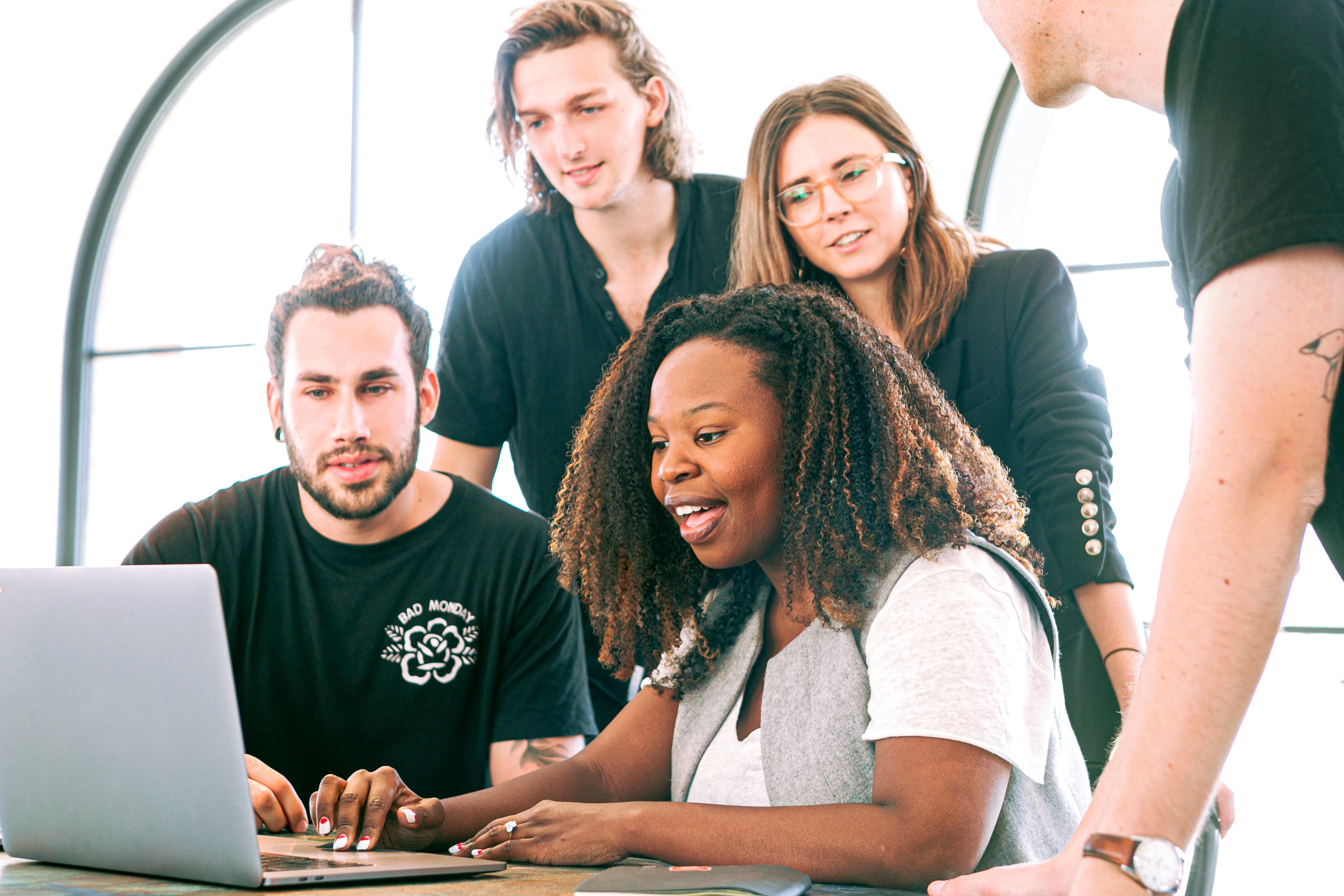 A woman showing employees something on a computer.